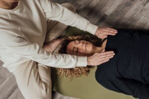 Una persona aplicando Reiki sobre otra